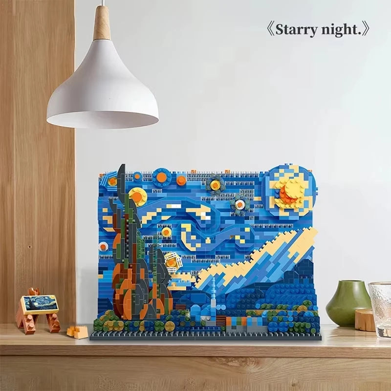 A Creative Art Van Gogh Paintings The Starry Night and The Great Wave of Kanagawa micro building blocks model (blue sky-no box) sits on a wooden surface under a white pendant lamp, with Starry night. written in the top right corner.