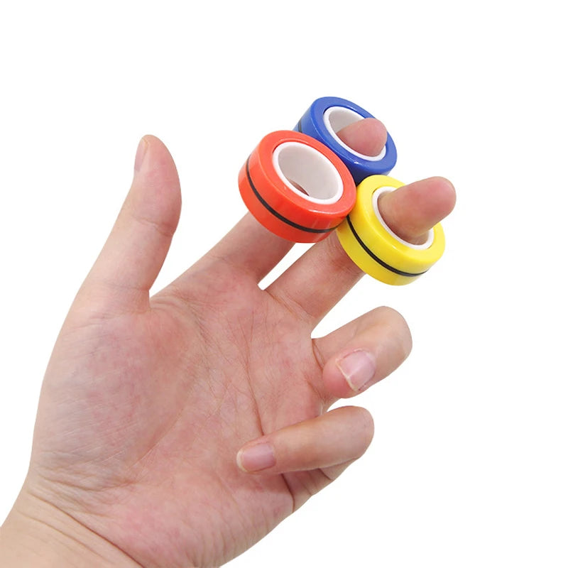 A hand with three fingers, each sporting a red, blue, and yellow 3PCS Finger Magnetic Rings Fidget Toy—gadgets designed for anxiety, ADHD, and stress relief.