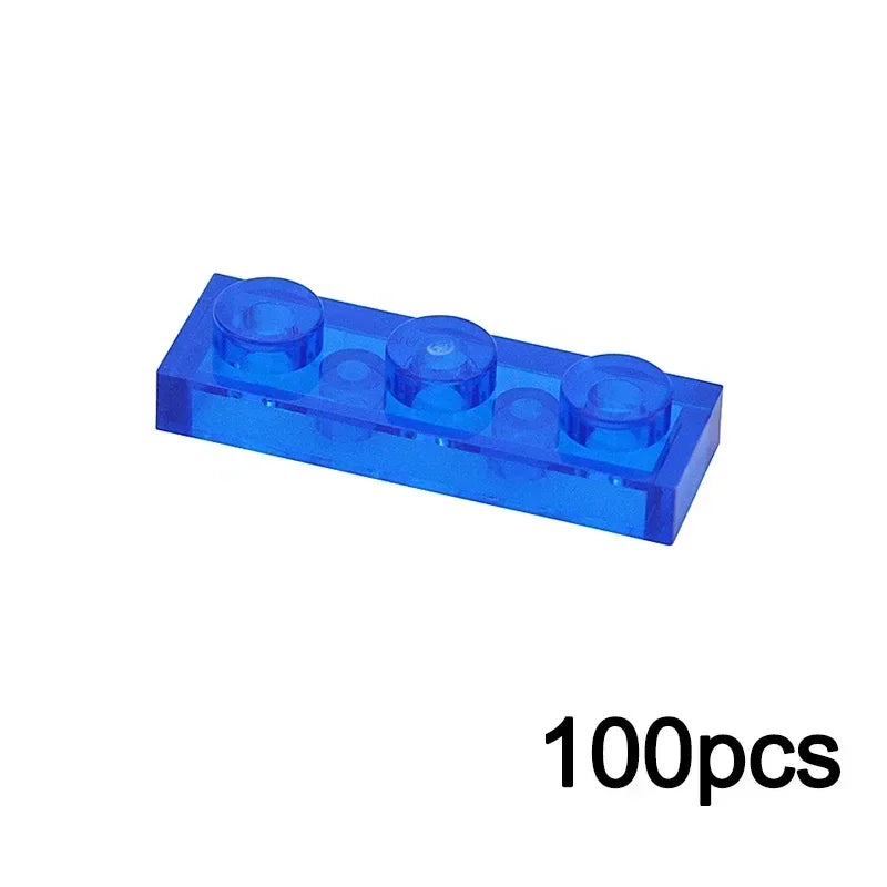 A 1x3 transparent blue MOC Bulk Brick, compatible with Lego, from the Clear Building Block Wall Panel House Parts set is pictured above 100pcs in black font.