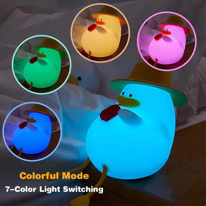 The Cute Cartoon Duck Rechargeable LED Night Light features a duck in a hat holding an object, emitting 7-switchable colors: green, pink, yellow, light blue, and white. Perfect as a portable silicone bedside lamp for kids room decor or as a birthday gift.