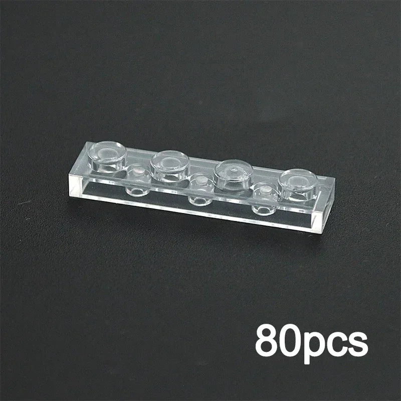 A 1x4 transparent brick from the MOC Transparent Bulk Brick Set, compatible with Lego, is shown on a dark surface. The “80pcs” in the corner highlights this clear building block set for walls and house parts.