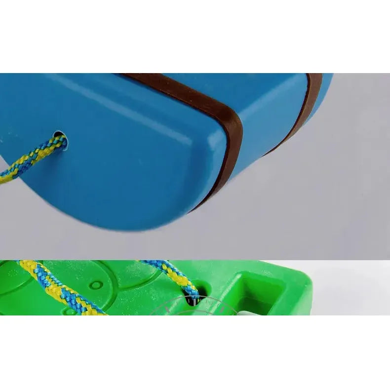 A close-up shows a blue and brown segmented balance board connected by a braided blue and yellow rope, with a green surface below featuring circular imprints, part of the Interactive Outdoor Balance Board Seesaw for Kids—perfect for sensory training, fitness, and fun.