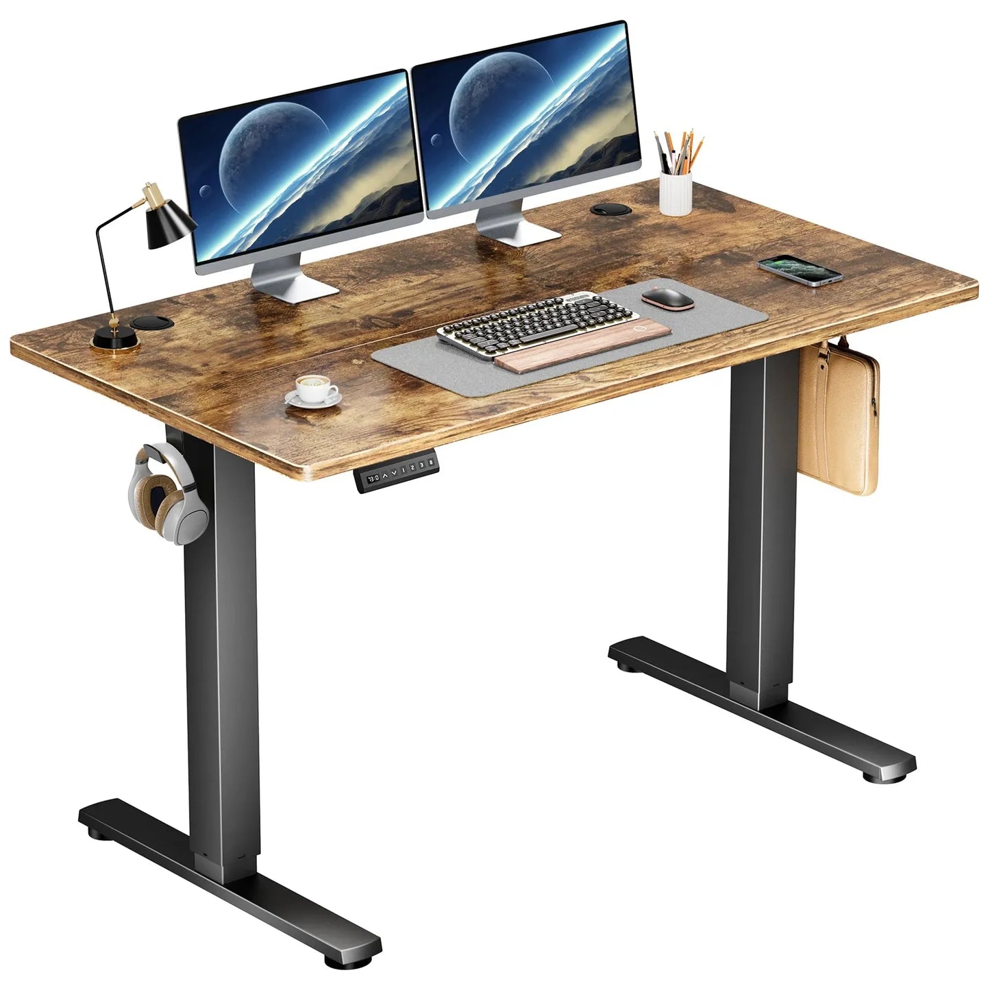 The JHK Electric Height Adjustable Standing Desk in Antique Wood Color is an ergonomic 40x24 inch sit-stand workstation. It features two monitors showing a space scene, keyboard, mouse, lamp, phone, stationery, with headphones hanging on the side and a shelf for pens, plus a height adjustment panel for personalized comfort.
