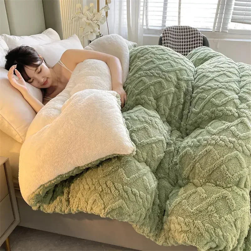 A person sleeps cozily in a bed with a large, plush green and white comforter as sunlight filters through blinds. A potted plant is visible in the background. The room has a peaceful and warm ambiance, enhanced by the Luxurious Artificial Cashmere Weighted Blanket for Ultimate Winter Comfort.