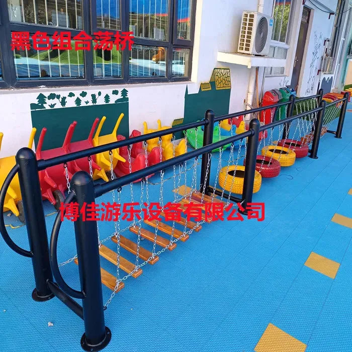 Colorful outdoor toys, including swings, climbing nets, and swinging bridges for physical training are set on a blue surface. This engaging area features unisex toys by a mural-adorned building. Red text overlays the image.