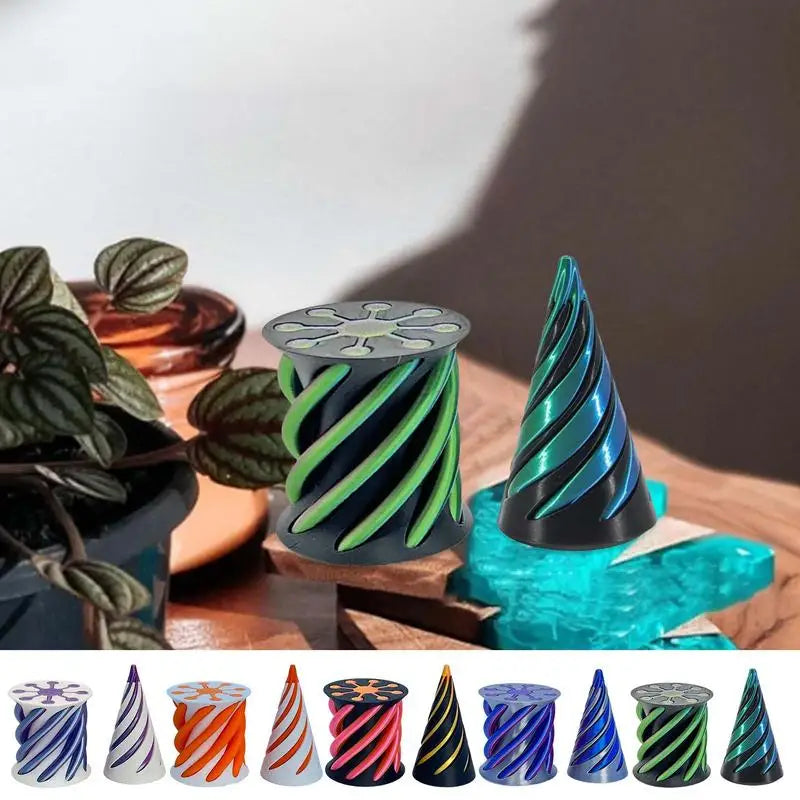 A range of colorful Impossible Cone Sensory Fidgets from the Impossible Cone collection are displayed with plants, a brown bottle, and blue stones—perfect for stylish desktop stress relief. The bottom row features cones in assorted color combinations.