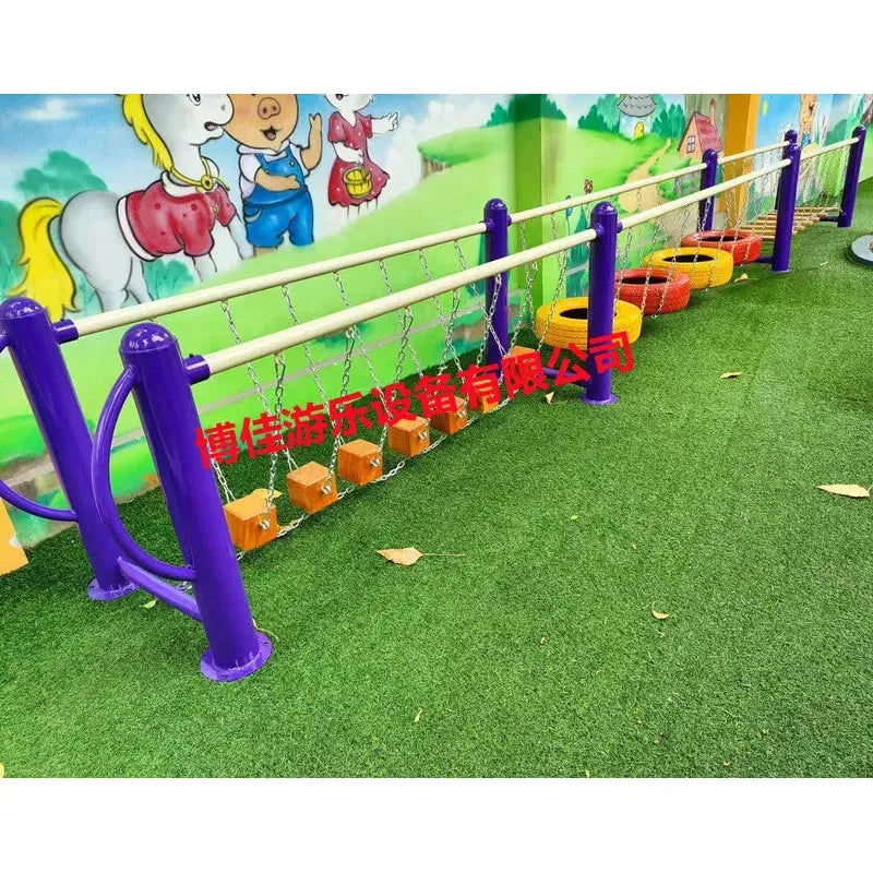A vibrant playground with purple rails, climbing nets, metal balance beams, and stepping tires on a green artificial grass surface. Designed for unisex fun for ages 3-8. The mural background features cartoon animals. Product: Childrens swings, climbing nets, swinging bridges, sensory training equipment.