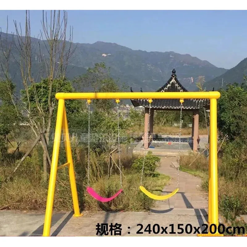An outdoor playground showcases an Outdoor Steel Climbing Frame Swing for Childrens Sensory Integration Training with a yellow set, featuring two swings in pink and yellow. The backdrop includes traditional Chinese architecture, scenic mountains, trees, and green foliage.