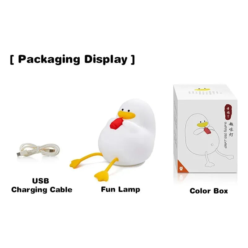 The Cute Cartoon Duck Rechargeable LED Night Light is a silicone bedside lamp shaped like a duck with orange feet and a red beak. It includes a USB charging cable and comes in a color box featuring its image, making it an adorable, portable addition to any room. Perfect for kids room decor or as a birthday gift.