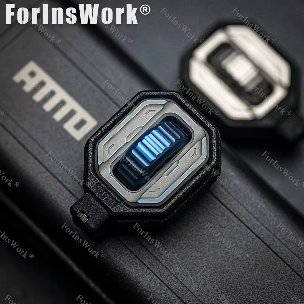 Close-up of the Ammo Cracker Unzip Roller Fidget Toy Stress Relief Slider EDC Tool, a futuristic rectangular keycap with metallic blue design, resting on a textured black surface. It provides stress relief while you work or play.