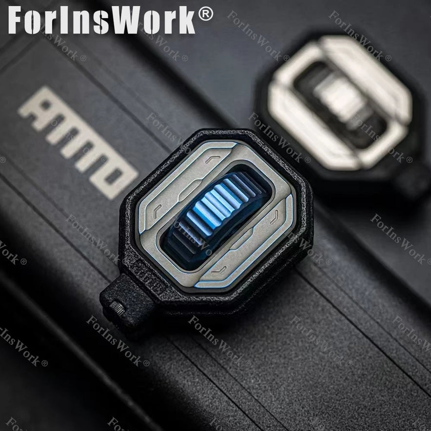Close-up of the Ammo Cracker Unzip Roller Fidget Toy Stress Relief Slider EDC Tool, a futuristic rectangular keycap with metallic blue design, resting on a textured black surface. It provides stress relief while you work or play.