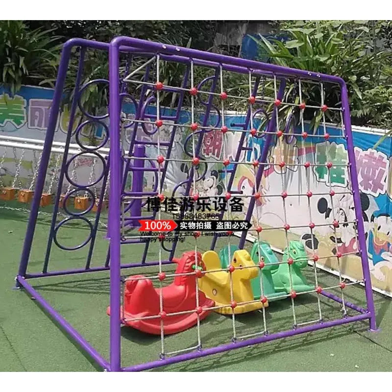 A unisex childrens playground structure features a climbing net on a purple metal frame. Beneath it, colorful red, yellow, and green metal duck-shaped toys sway gently. This charming outdoor playground sports equipment suits ages 3-8 and is framed by decorative walls in the background.