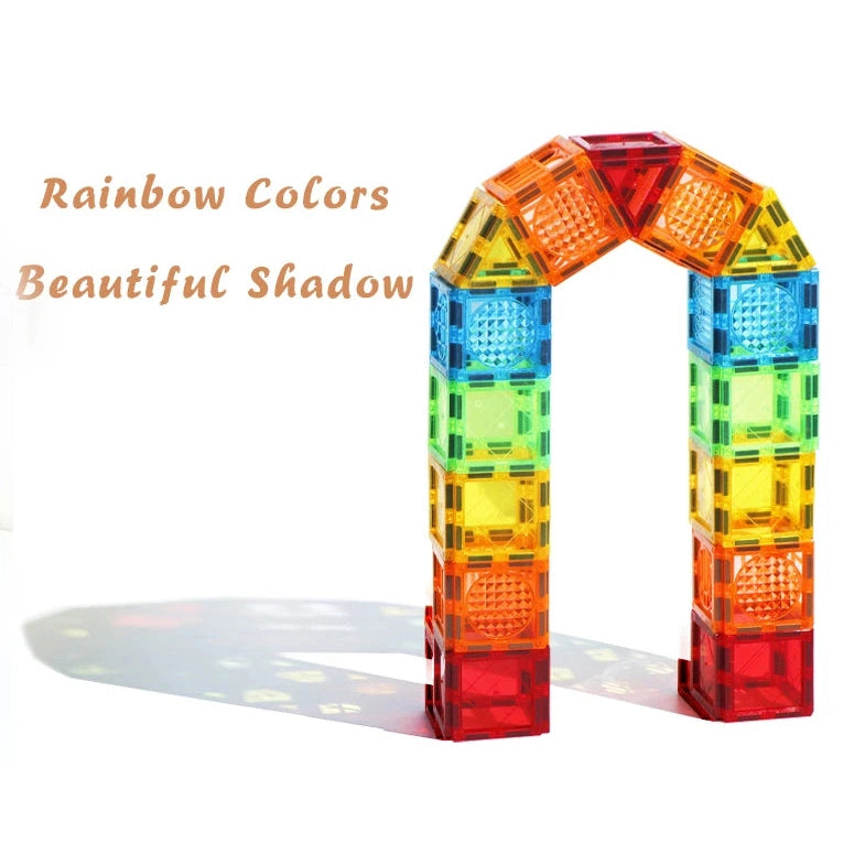 Translucent, interlocking blocks from the Creative Magnetic Building Blocks Set for Kids form a colorful arch casting a vivid shadow on a white surface. It reads Rainbow Colors Beautiful Shadow in warm gold, highlighting this educational toys creativity.