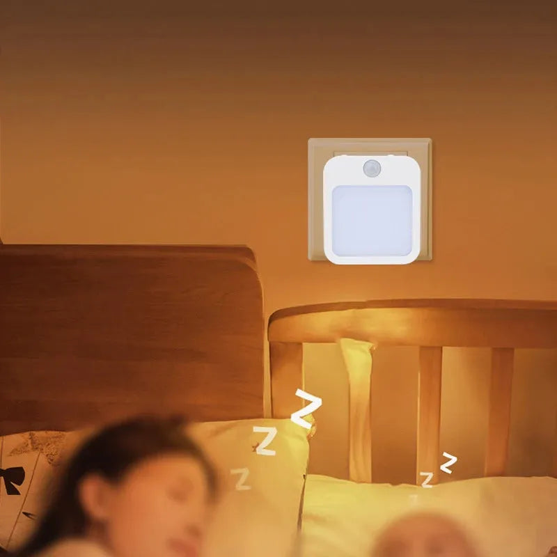 A peaceful person sleeps in a warmly lit room, with the Dimmable Motion Sensor LED Night Light featuring an EU plug casting a soft glow above a wooden crib. This energy-efficient, wireless lighting solution ensures tranquility throughout the night in the babys room.
