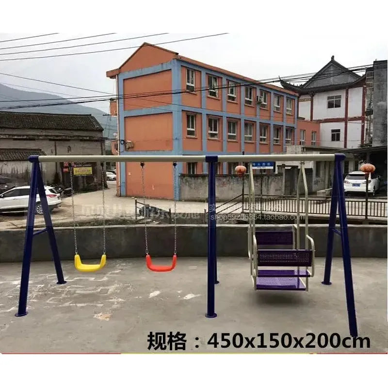 A 450x150x200 cm Outdoor Steel Climbing Frame Swing for childrens sensory integration includes two swings (yellow, red) and a metal basket swing. It stands before an orange multi-story building with blue accents amidst power lines and a mountainous backdrop.