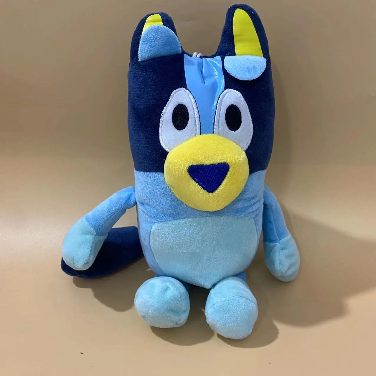 This 17cm Bluey & Bingo Family Plush Toy features the elder brother cartoon dog with light and dark blue patches, large eyes, a yellow snout, and inner ears, sitting upright—perfect for birthday or Christmas gifts.