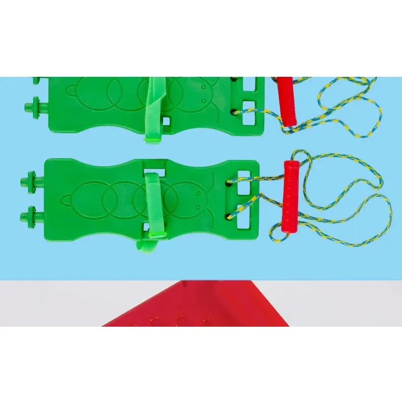 Two green plastic swing seats with colorful ropes attached to red handles, set against a blue background, create the perfect outdoor toy. A red triangular shape is partially visible at the bottom of the image, adding intrigue to this vibrant scene. Featured: Interactive Outdoor Balance Board Seesaw for Kids.