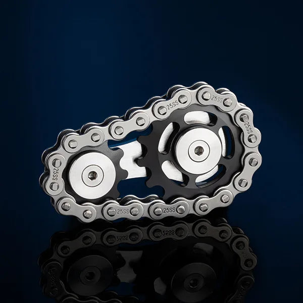 A silver bicycle chain forms two gear-like wheels, resembling the Bike Chain Metal Fidget Spinner with Magnetic Slider against a dark blue background. Its reflection adds depth below, embodying stress relief.