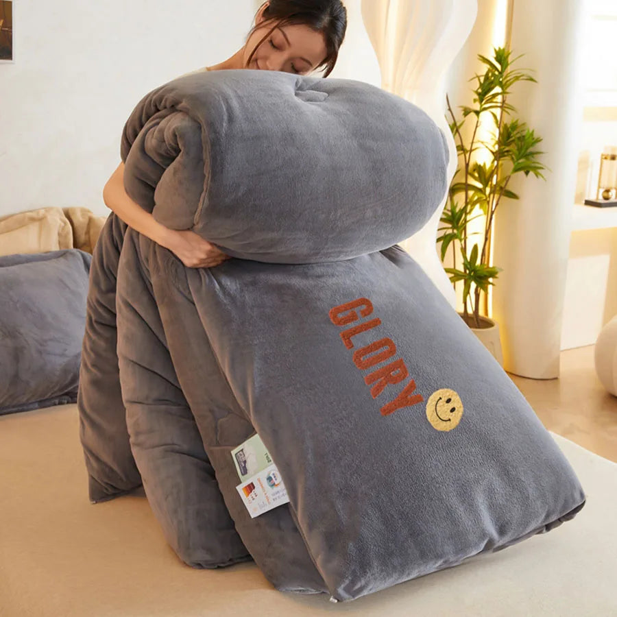 A person cuddles a KDJEIKZ Ultra Cozy Winter Weighted Blanket made of luxurious milk velvet, embroidered with GLORY and a smiley face. The softly lit room has neutral-toned furnishings and a potted plant in the background.