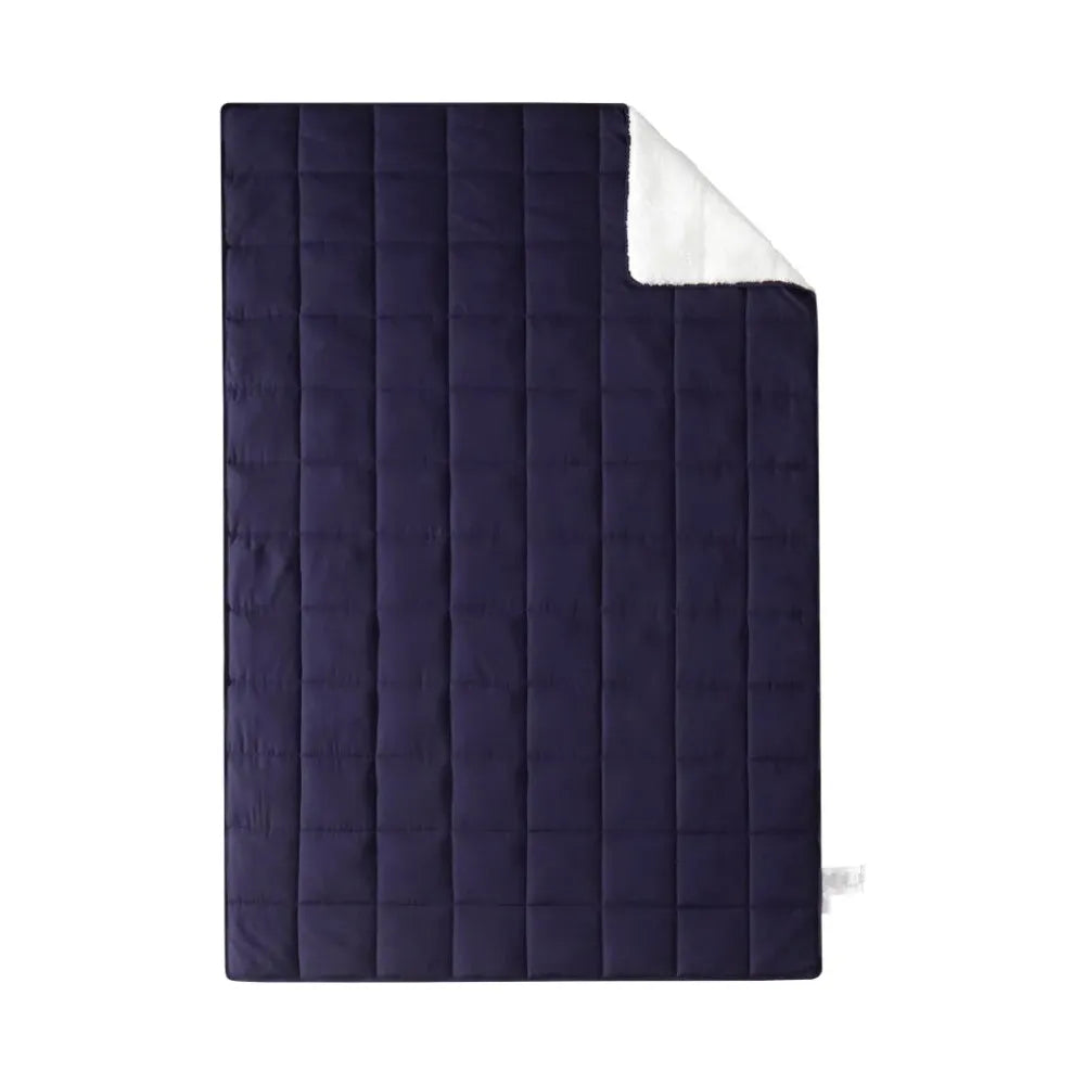 The Luxurious Microfiber Weighted Blanket is shown in navy blue with a quilted pattern and folded top right corner revealing its plush, white underside, emphasizing its opulent design.