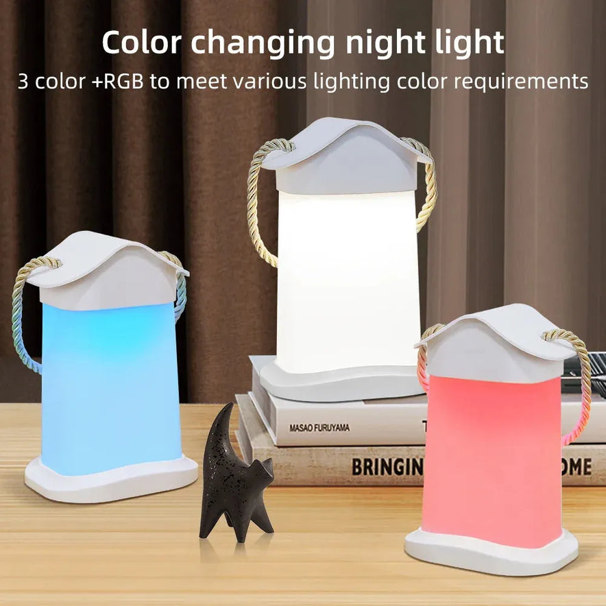 Three lantern-shaped LED night lights in white, blue, and pink sit on a table with a black cat figurine and books. Text reads, Rechargeable Dimmable Touch LED Night Light Table Lamp: 3 colors + RGB to suit any mood. Perfect for bedroom decor or as a Christmas gift for kids.