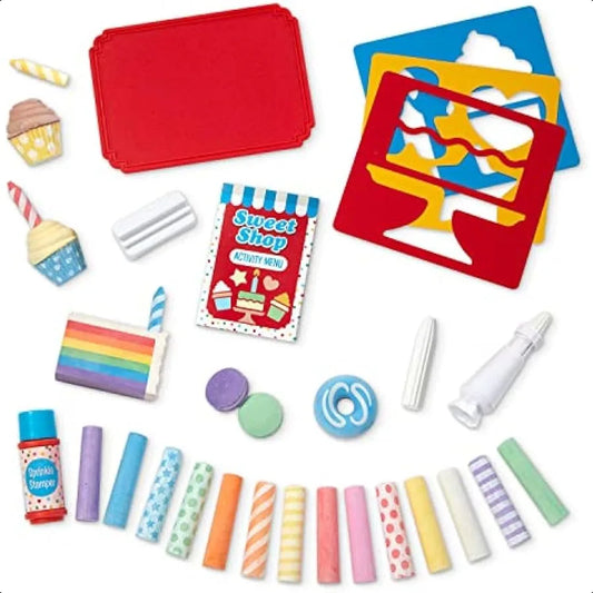 The Melissa and Doug Sweet Shop Multicolored Chalk and Holders Play Set (33 pieces) includes dustless chalk, cupcake and cake toys, a red tray, stencils, menu card, candles, sprinkle shaker, icing tube, and macarons—perfect for creative play.
