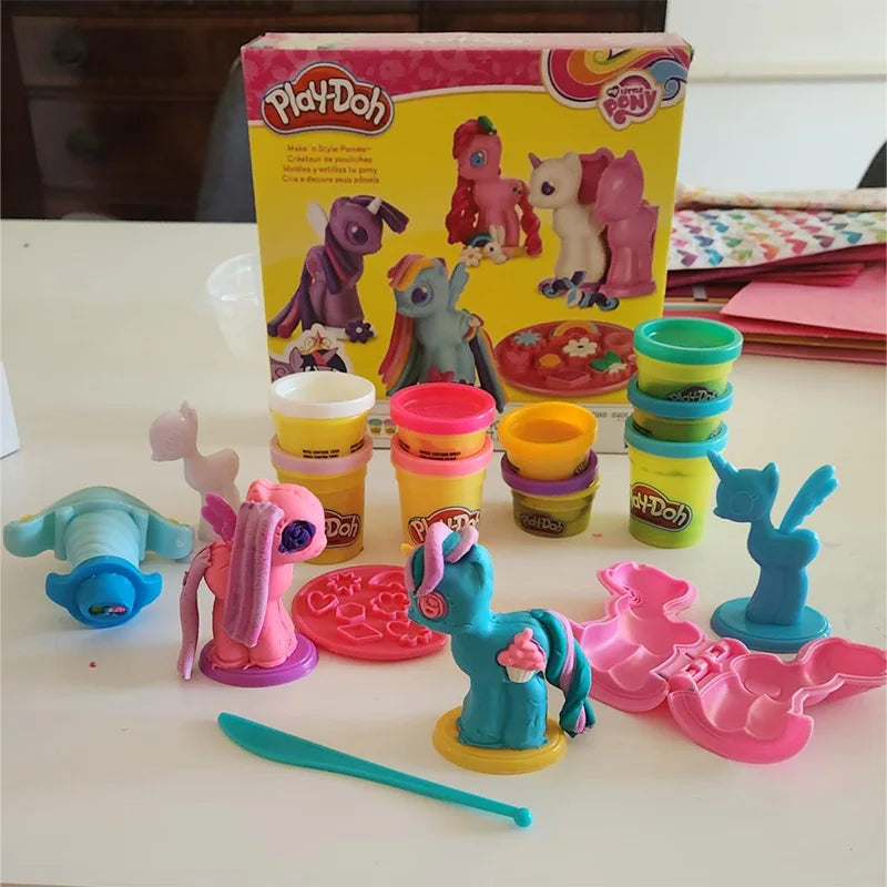 The My Little Pony Play-Doh Modeling Compound Make n Style Ponies set includes vibrant dough jars and cute pony figures. The packaging, adorned with pony illustrations and colorful molds, exudes creativity reminiscent of TAKARA TOMYs imaginative finished goods models. Perfect for Easter basket stuffers!.