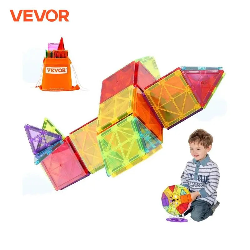 A child joyfully builds with VEVORs 121PCS Magnetic Building Blocks Set, crafting geometric shapes. In the background, an orange storage bag with Vevor branding is filled with extra plastic ferrite tiles for endless creative fun.