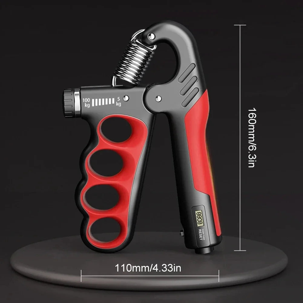 The Hand Gripper for Muscle Development and Fitness Workouts, featuring a robust metal spring on a black platform, is red and black with adjustable resistance. It includes measurement markings up to 100kg and measures 110mm/4.33in wide by 160mm/6.3in tall, ideal for strength exercises.