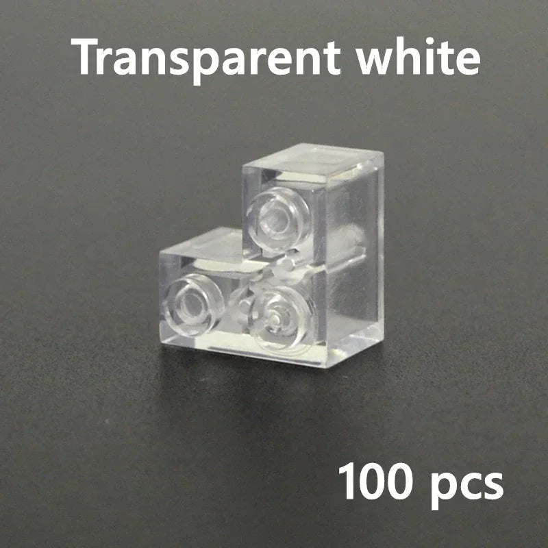 A white L-shaped transparent MOC brick, compatible with Lego, is displayed on a dark surface. White L appears above and 100 pcs—ideal for expanding your building block collection is shown below.