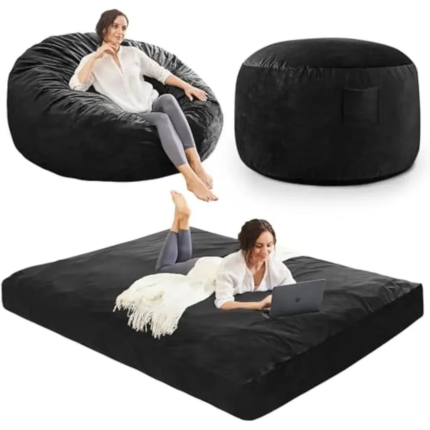 A woman relaxes on the Queen-Carbon Black Convertible Bean Bag Bed, which transforms from chair to ottoman to flat mattress. She’s reading and working on a laptop, demonstrating the versatile microfiber furniture in three configurations.