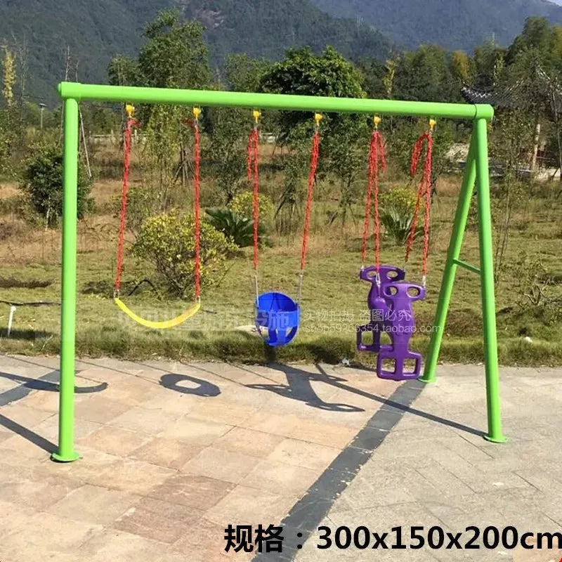 The Outdoor Steel Climbing Frame Swing for Childrens Sensory Integration Training features three swings in yellow, blue, and purple. Set in a green frame on a paved area with trees and mountains as the backdrop, this colorful play equipment enhances any outdoor space.