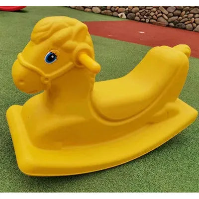 A Monochrome Wooden Rocking Horse for Toddlers sits on a playground with a green rubber surface, featuring a simple design perfect as a toddler gift. Stone borders and patches of red accentuate the lively background.