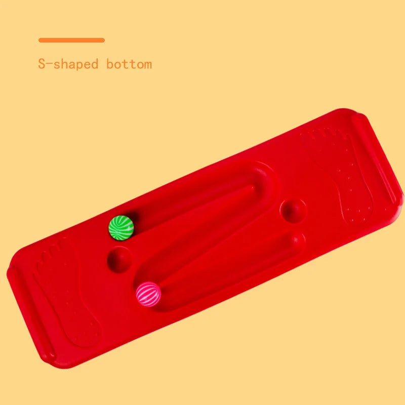 The Interactive Outdoor Balance Board Seesaw for Kids is red with an S-shaped groove, foot imprints on each side, and includes two textured balls (green and pink). Text reads S-shaped bottom on a yellow background. Ideal for outdoor fun, it enhances balance skills through sensory training.