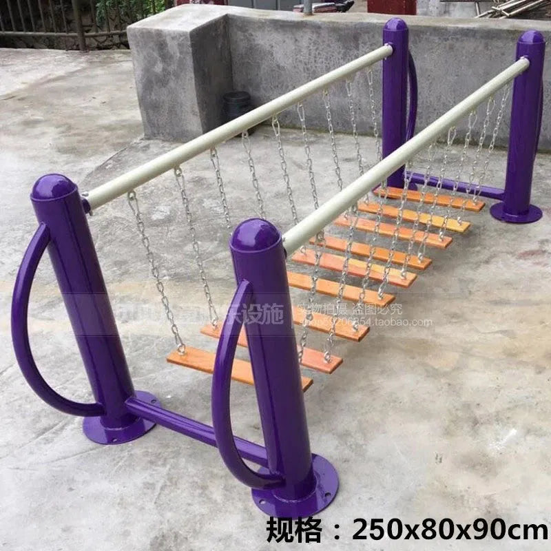 The Outdoor Steel Climbing Frame Swing, designed for childrens sensory integration, features wooden steps suspended by chains between two purple metal frames. It measures 250x80x90 cm and is securely placed on a concrete surface.