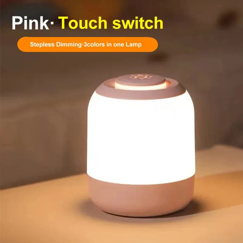A small pink LED table lamp with a touch sensor and stepless dimming offers three color options on a surface. USB rechargeable, it emits a warm, soft glow. Text reads Pink Touch Sensor, Stepless Dimming, 3 Colors in One Lamp. Product: Touch Control LED Night Light Lamp – Ideal for kids.