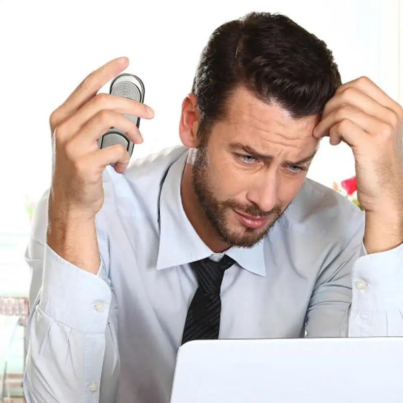 A stressed man in a shirt and tie sits before his laptop, holding his forehead and phone—he could use the silver Fidget Slider Magnetic Metal Spinner Toy to relieve tension during home, travel, or school planning.