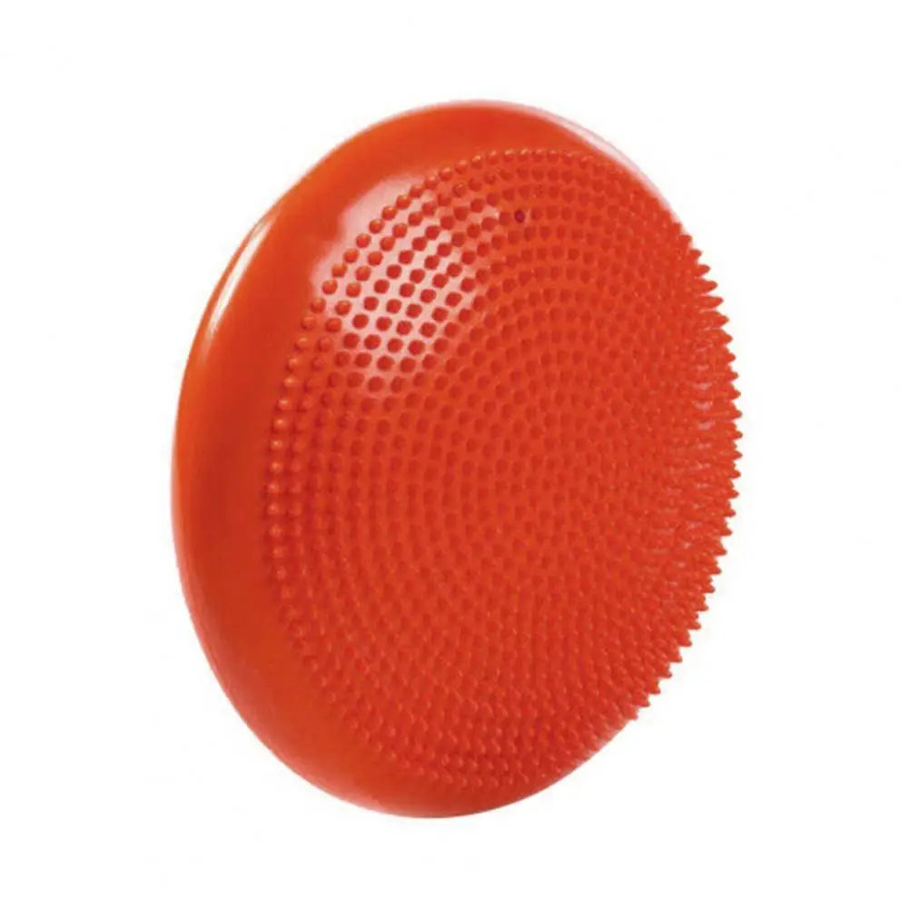 A balance disc from the Non-Slip Balance Training Mat Set, featuring a red, round design with a textured surface, aids in stability exercises and enhances core strength during yoga sessions.