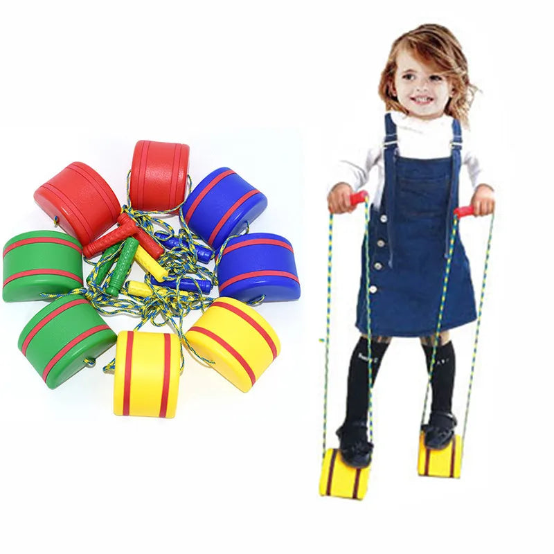 A child plays on an Interactive Outdoor Balance Board Seesaw for Kids, a fun sensory training toy. Nearby, similar bright stilets in red, green, blue, and yellow with striped ropes await. Perfect for enhancing balance skills and fitness.