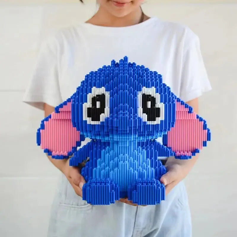 A person in a white shirt holds the Large Stitch Building Block Assembly Toy, a 30cm 3D DIY childrens puzzle with big eyes and pink ears—perfect as a birthday gift or desktop decoration.