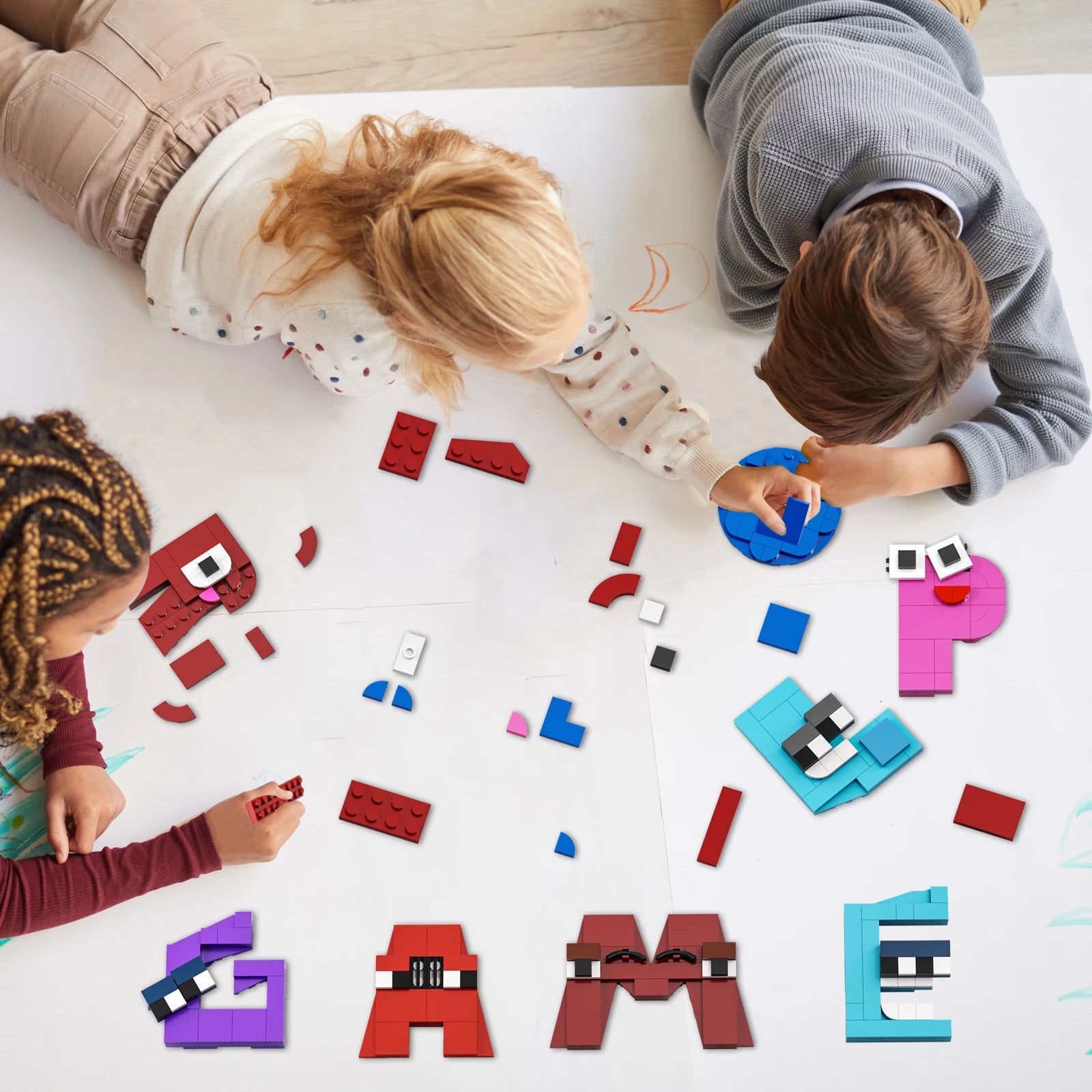 Three children play on the floor with the Gobricks MOC Letters Lore A-Z English Alphabet Building Blocks Set, creating letter shapes and spelling words as they enjoy fun, hands-on educational play on a white surface.