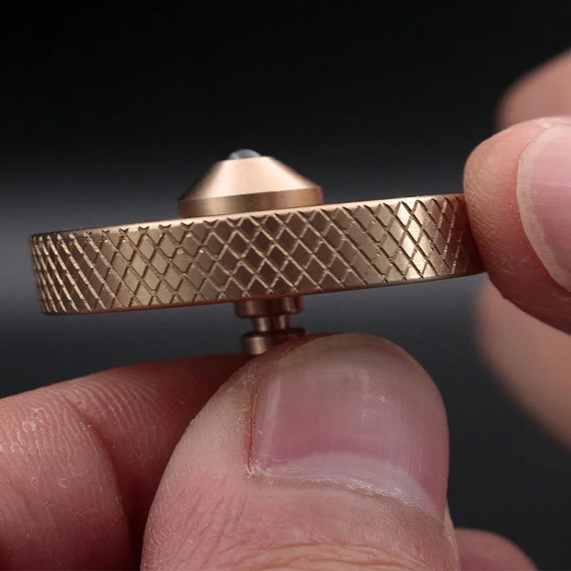 Close-up of a hand holding the Creative Whirlwind Fidget Spinner, featuring a textured, diamond-patterned edge and pointed tip. This innovative tool offers stress relief against the soft focus black background, highlighting its metallic finish. Perfect for kids & adults.