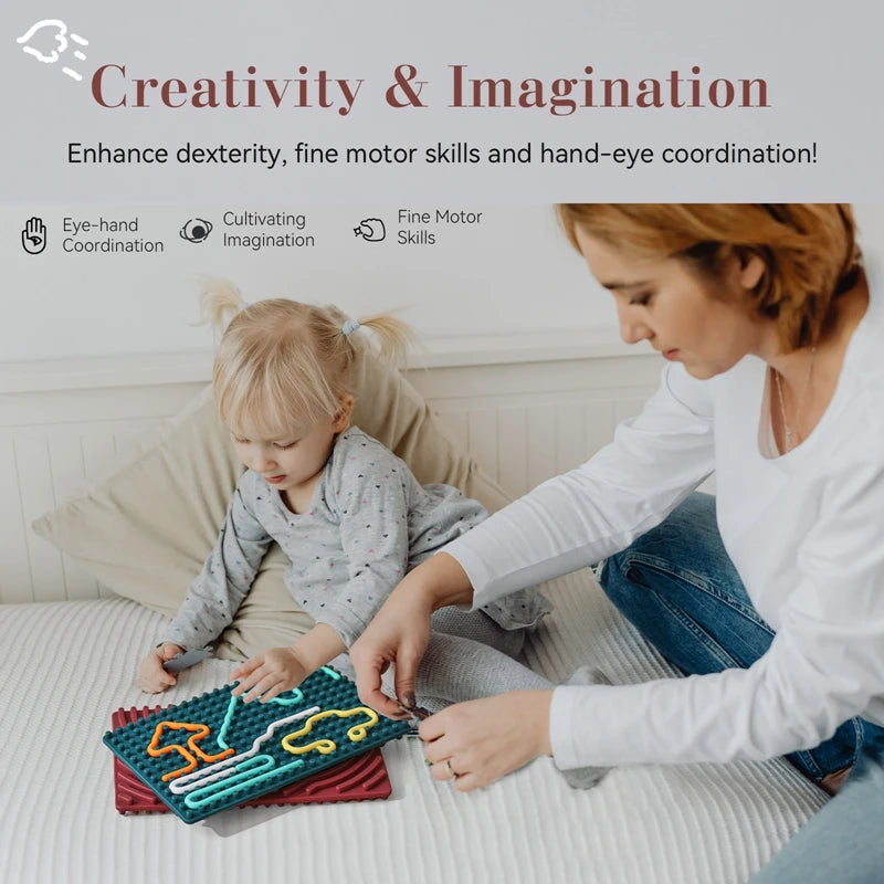 A woman and a young girl sit on a bed playing with the Silicone Montessori Sensory Activity Board Fidget Toy for Kids, which encourages creativity, fine motor skills, hand-eye coordination, and provides anxiety relief through interactive play.
