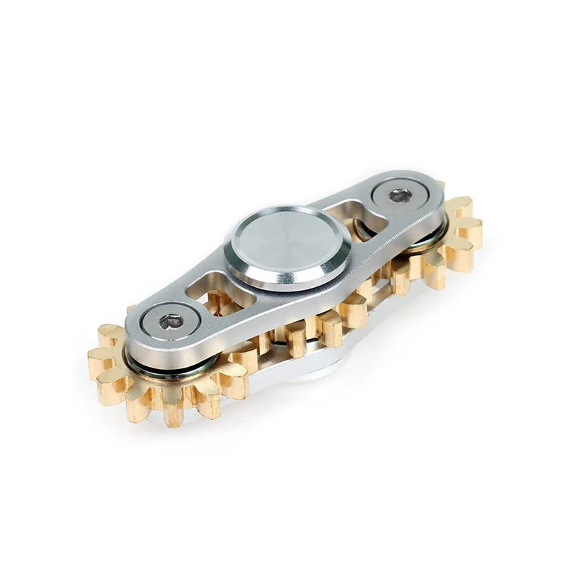 A Bike Chain Metal Fidget Spinner with a steampunk design features brass-colored gears around the edges and a polished silver center, showcased on a white background to highlight its intricate details.