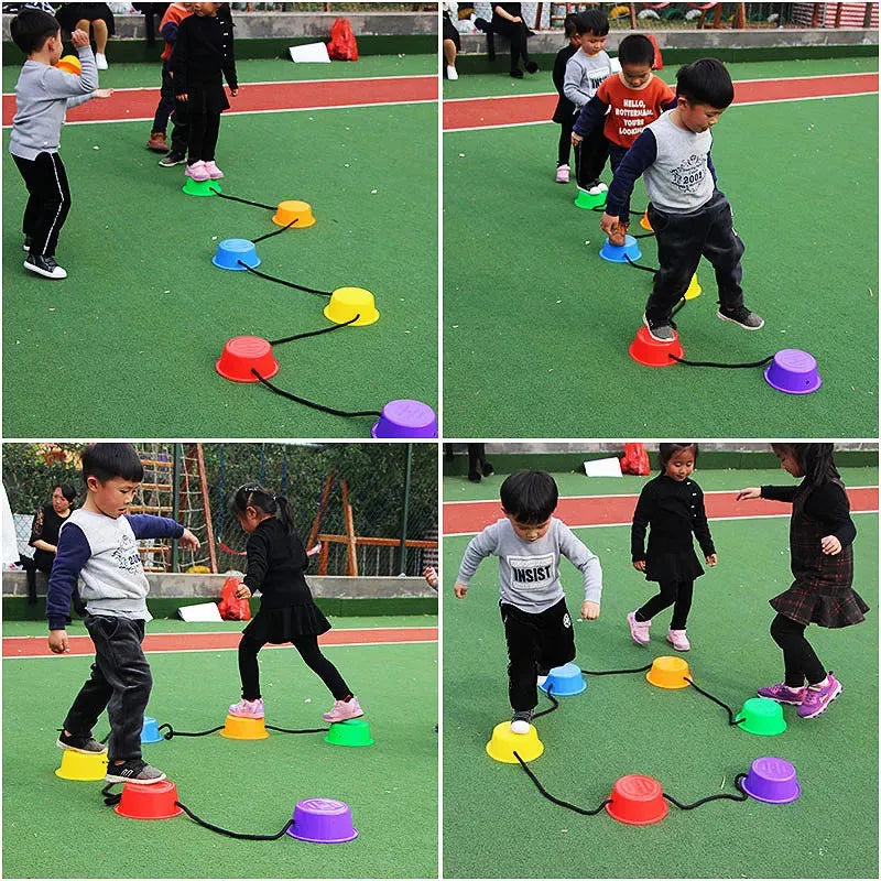 Children are hopping across a playground on ropes linked to Montessori Sensory Integration Foot Toys for Kids, which help balance training. Theyre playing on green artificial turf, dressed casually.