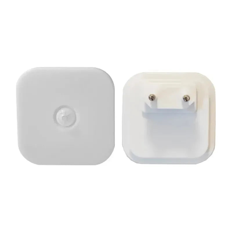 The Dimmable Motion Sensor LED Night Light features a white square-shaped adapter with a circular button on the front for energy-efficient use, and two metal prongs on the back for EU plug sockets. Ideal for a babys room, bedroom, or corridor as a wireless lighting solution.
