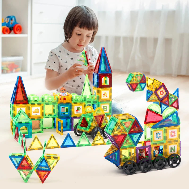A child constructs geometric shapes and structures on the floor using Magplayer Magnetic Tiles Construction Set for Creative Kids, promoting cognitive development by building towers and vehicles. The Montessori educational toy inspires colorful creations in a bright, cozy room.