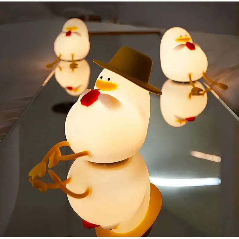 Three cartoonish egg-shaped figures with yellow feet and red beaks stand on a reflective surface, resembling the Cute Cartoon Duck Rechargeable LED Night Light. The front figure wears a brown hat, creating a whimsical scene accented by mirrored reflections.