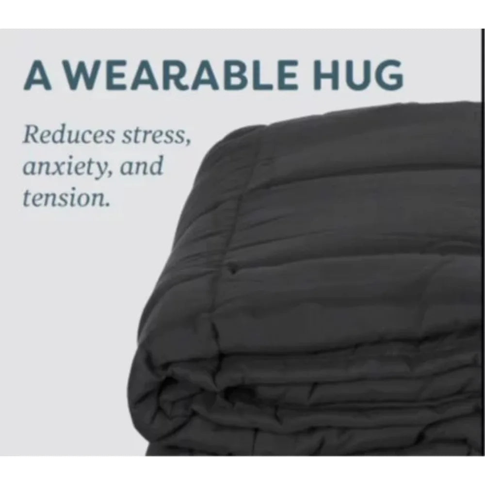 A plush 20lb dark gray weighted blanket, designed to soothe and relax, is neatly folded with A Wearable Hug text above. Its crafted in the US to reduce stress, anxiety, and tension.