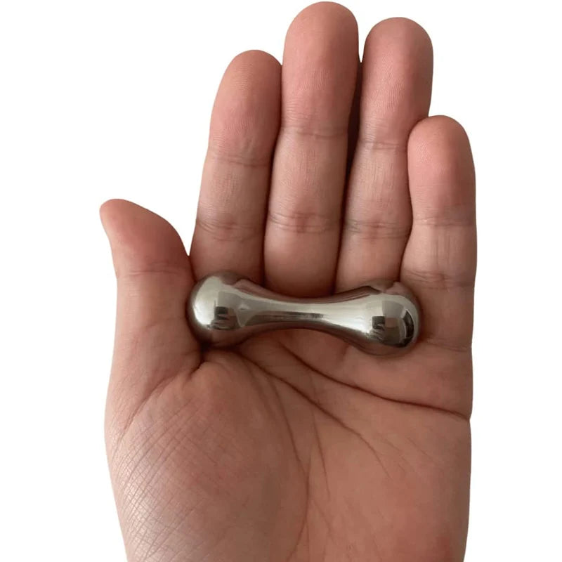 A hand holds a metallic Stainless Steel Knucklebone Fidget Tool, smooth and shiny like a dumbbell, for anxiety relief and dexterity enhancement as it glides reflectively between fingers.